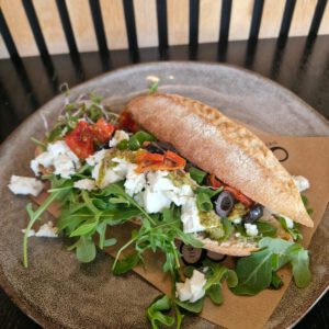 Broodje Feta, zwarte olijven, groene pesto, rucola, bosui en zongedroogde tomaatjes