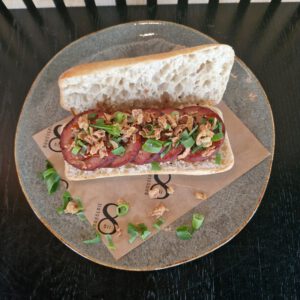 Warme grillworst met oosterse sesamsaus, bosui en gefrituurde uitjes