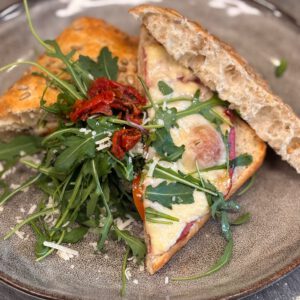 Salami, rode ui, tomaatjes, chilisaus en kaas uit de oven