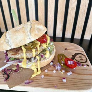 Kipburger met Italiaanse bol, sla, kerrie-mayonaise, rode ui en jalapeno-pepers